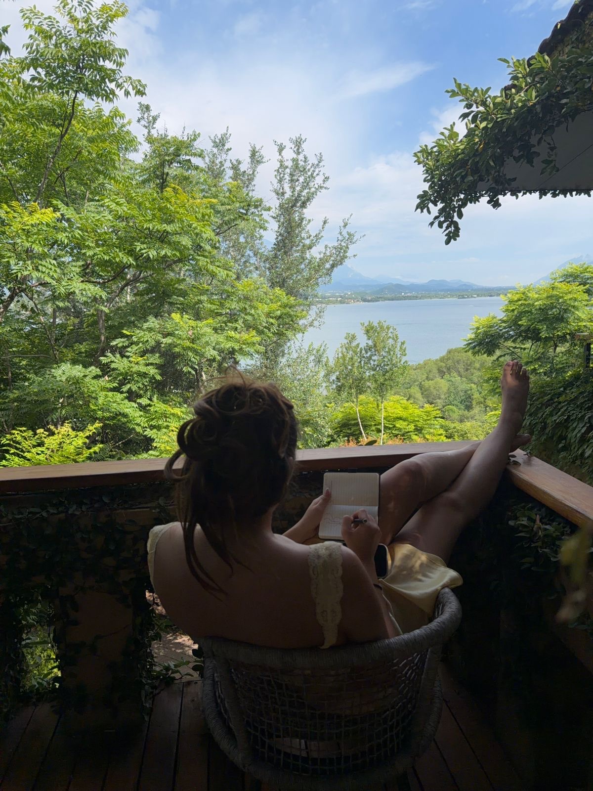 Fátima escribiendo en su cuaderno frente al lago